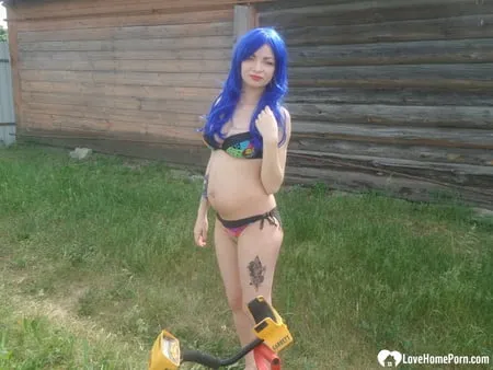 blue haired beauty showing her bust while gardening         