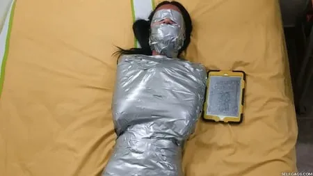 young girl duct tape wrapped like an egyptian mummy         