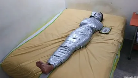 young girl duct tape wrapped like an egyptian mummy         