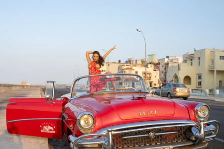 monika fox in red dress on waterfront in rare car         