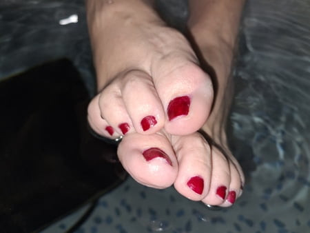 Yeni kırmızı pedikürlü ayaklarını gösteriyor