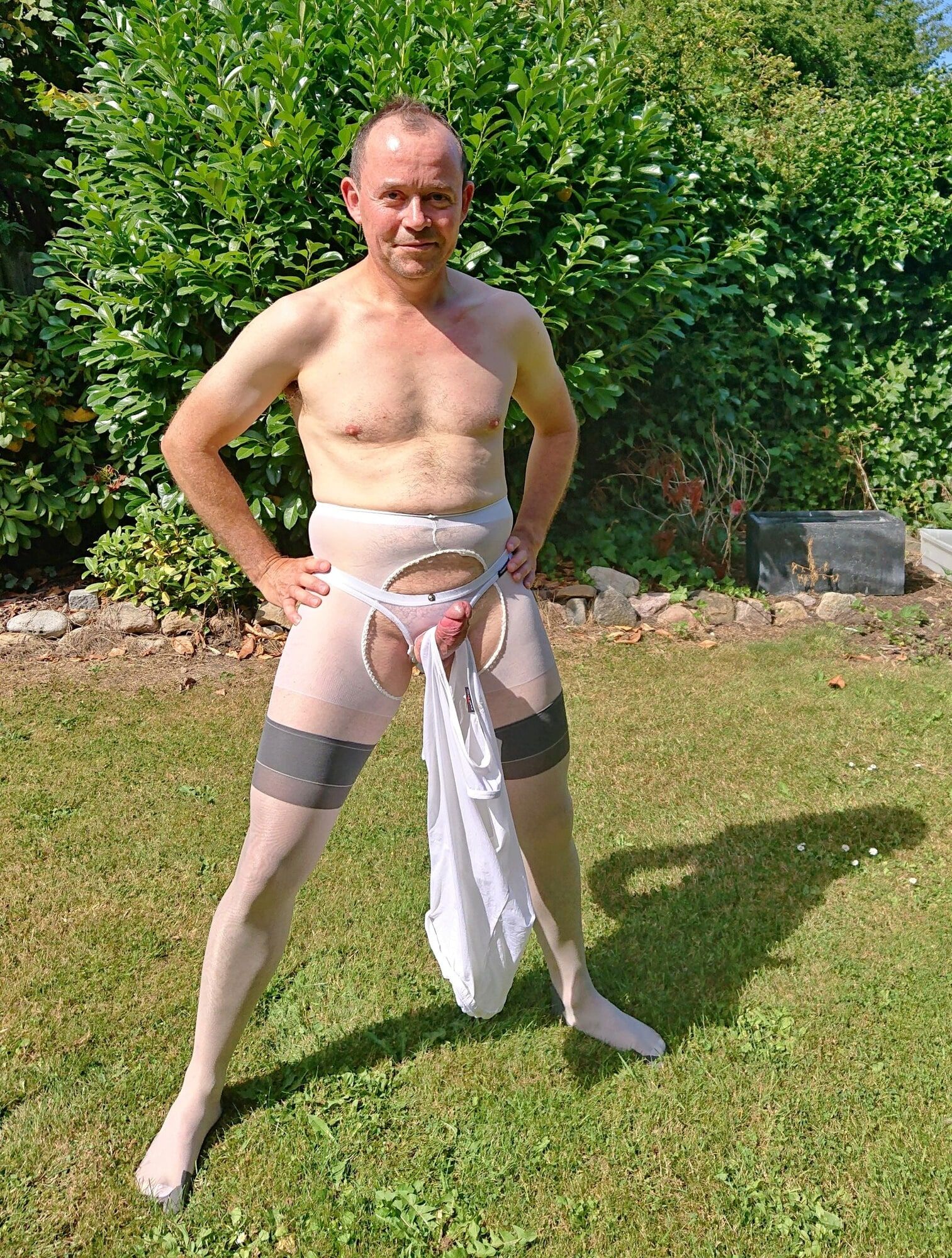 Posing in sexy nylon lingerie in a garden