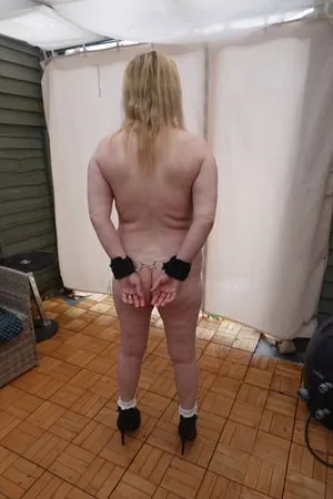 slave cuffed naked in ankle boots in the cold yard         