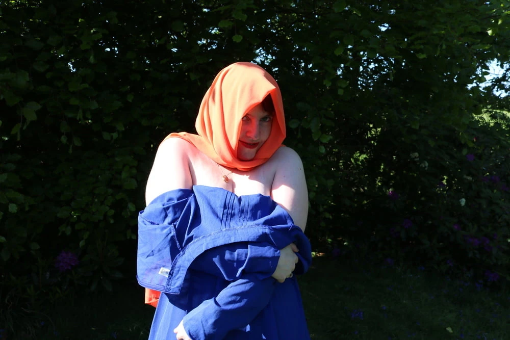 hijab and abaya flashing outdoors 