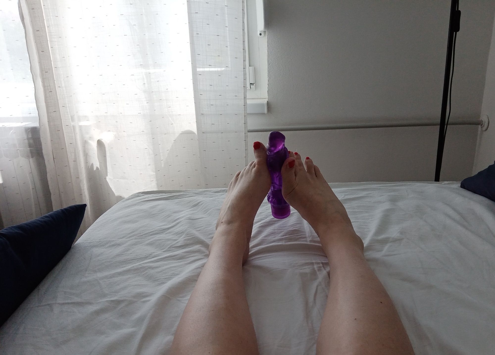 Tranny in a lying position simulates a Footjob with vibrator