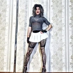 Beautiful long-legged bitch poses in a new white mini skirt