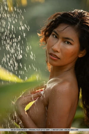 thai beauty niki smiling as the water cascade down over her sexy body         