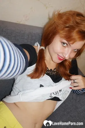 Redhead lifts her shirt to show her tits         