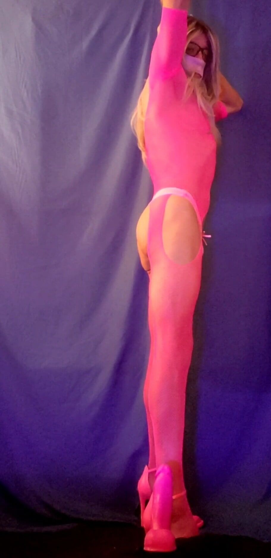 Pink bodystocking and dildo in black light
