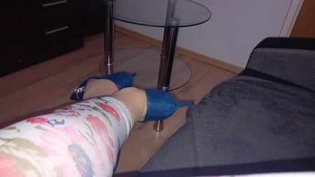 Crossdresser W seksownych niebieskich dżinsach wskazał na wysokie obcasy toe toe