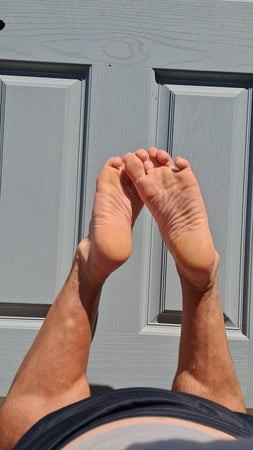 Sneaky shots sexy male feet while tanning