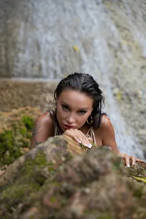 wet monika fox in a net near a waterfall         