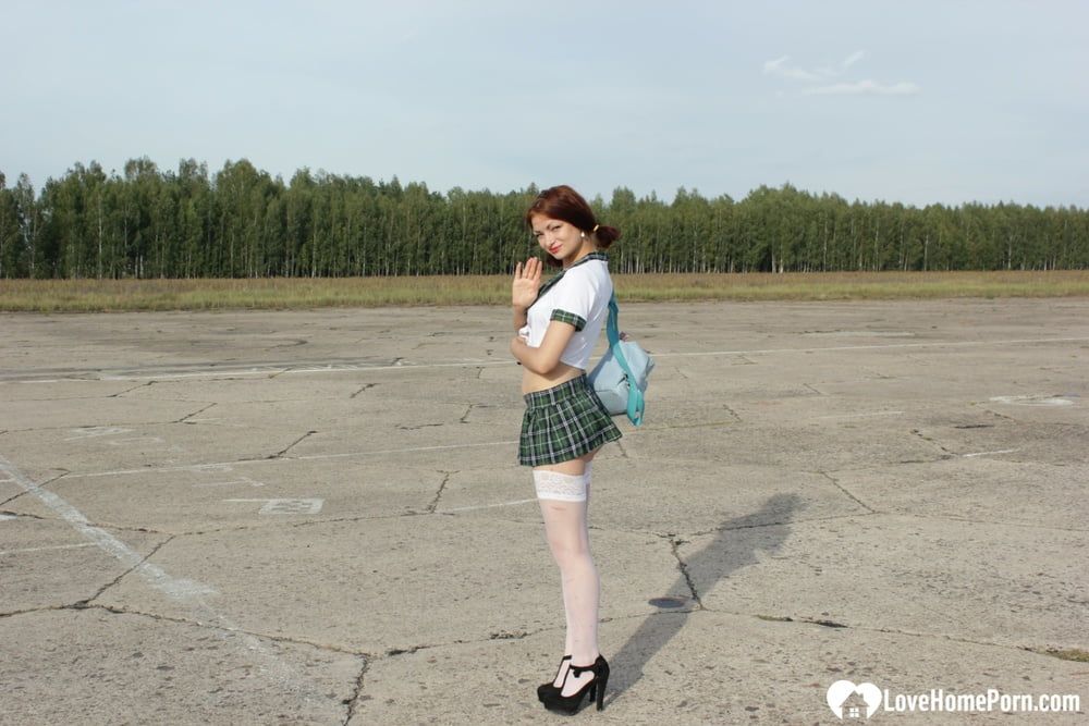 Incredible mom in a schoolgirl outfit posing outdoors