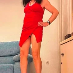 Beautiful shemale poses high heels red dress living room