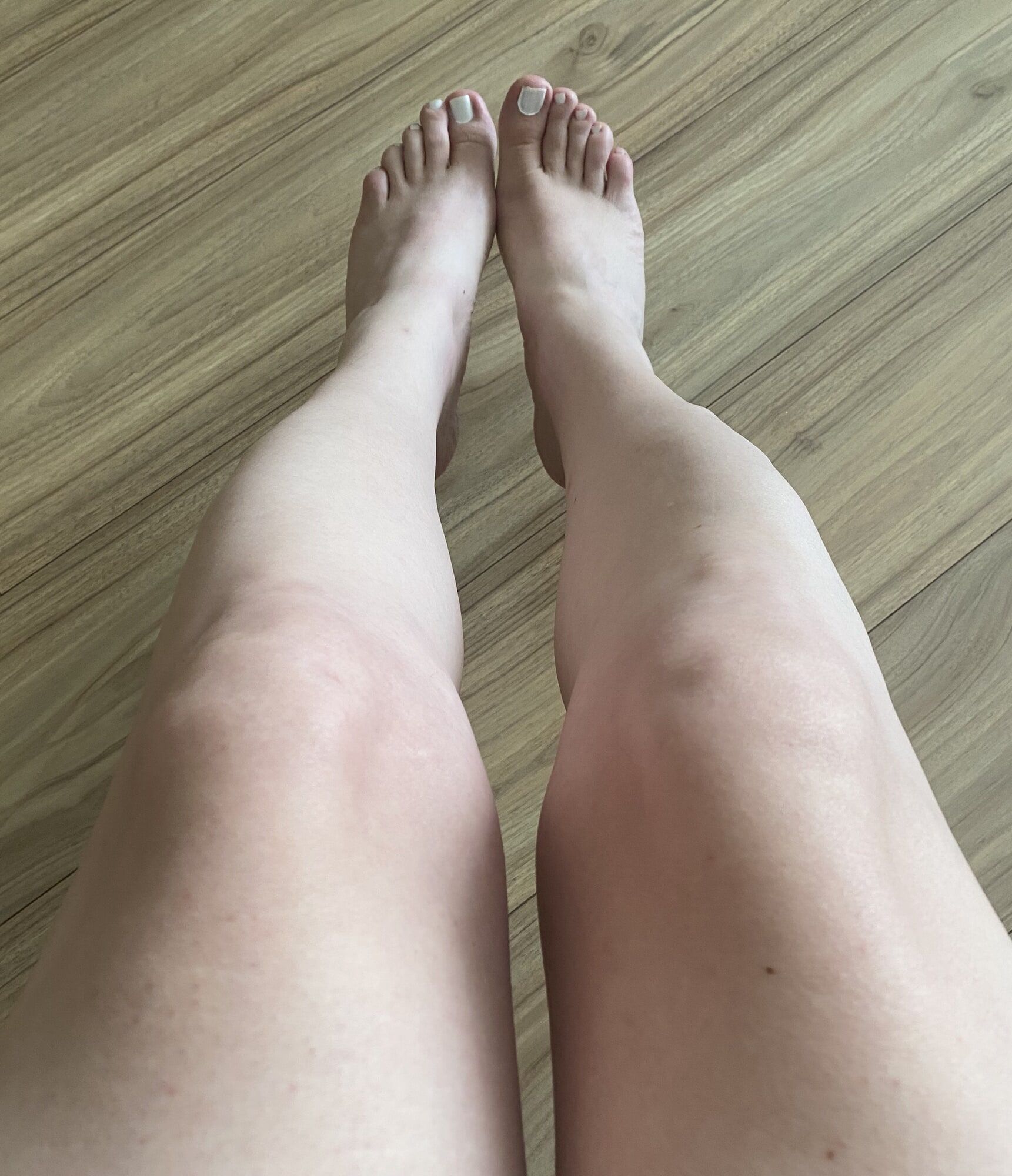 White polished nails and shaved legs