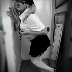おさげ髪のセクシーなブロンドの女子高生が白いストッキングでポーズをとる