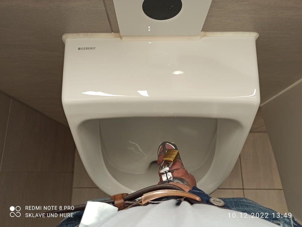 Pissing with cockcage in public urinal