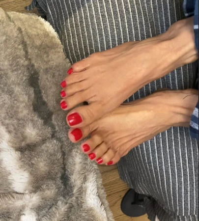 Melove nel suo smalto rosso dita dei piedi lunghi e piedi piccoli 