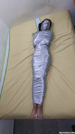 young girl duct tape wrapped like an egyptian mummy         