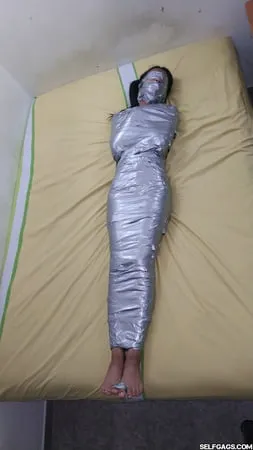 young girl duct tape wrapped like an egyptian mummy         