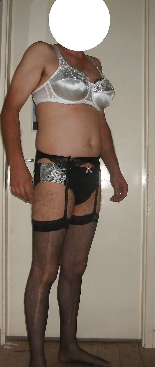 Crossdressing in a white bra and black panties, stockings.