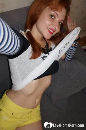 Redhead lifts her shirt to show her tits         
