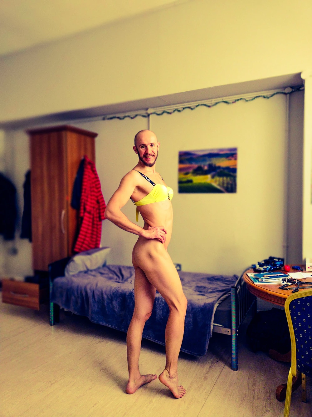 Bearded athletic man posing in yellow swimsuit 