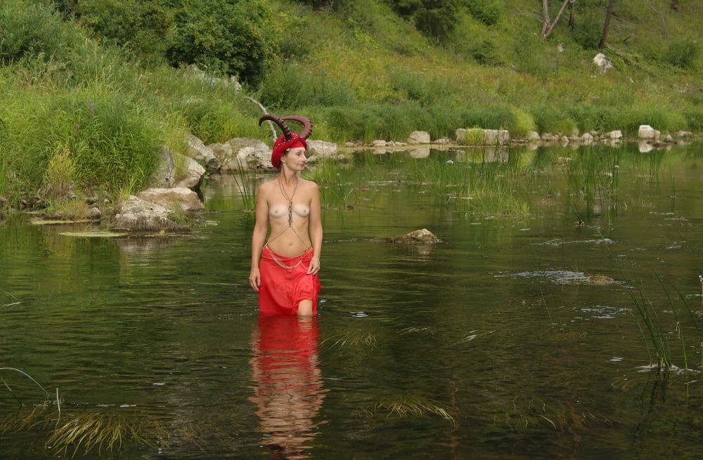 With Horns In Red Dress In Shallow River