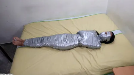 young girl duct tape wrapped like an egyptian mummy         