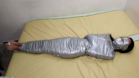 young girl duct tape wrapped like an egyptian mummy         