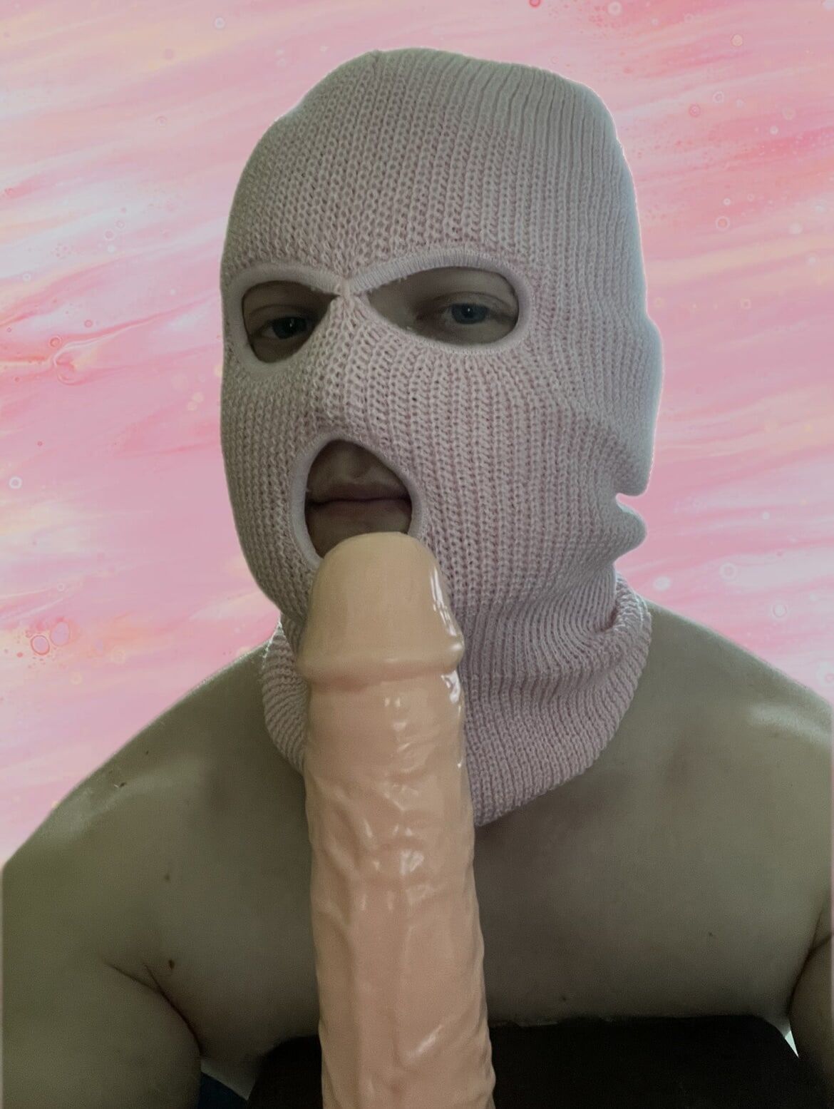 Playing with a dildo in a pink mask