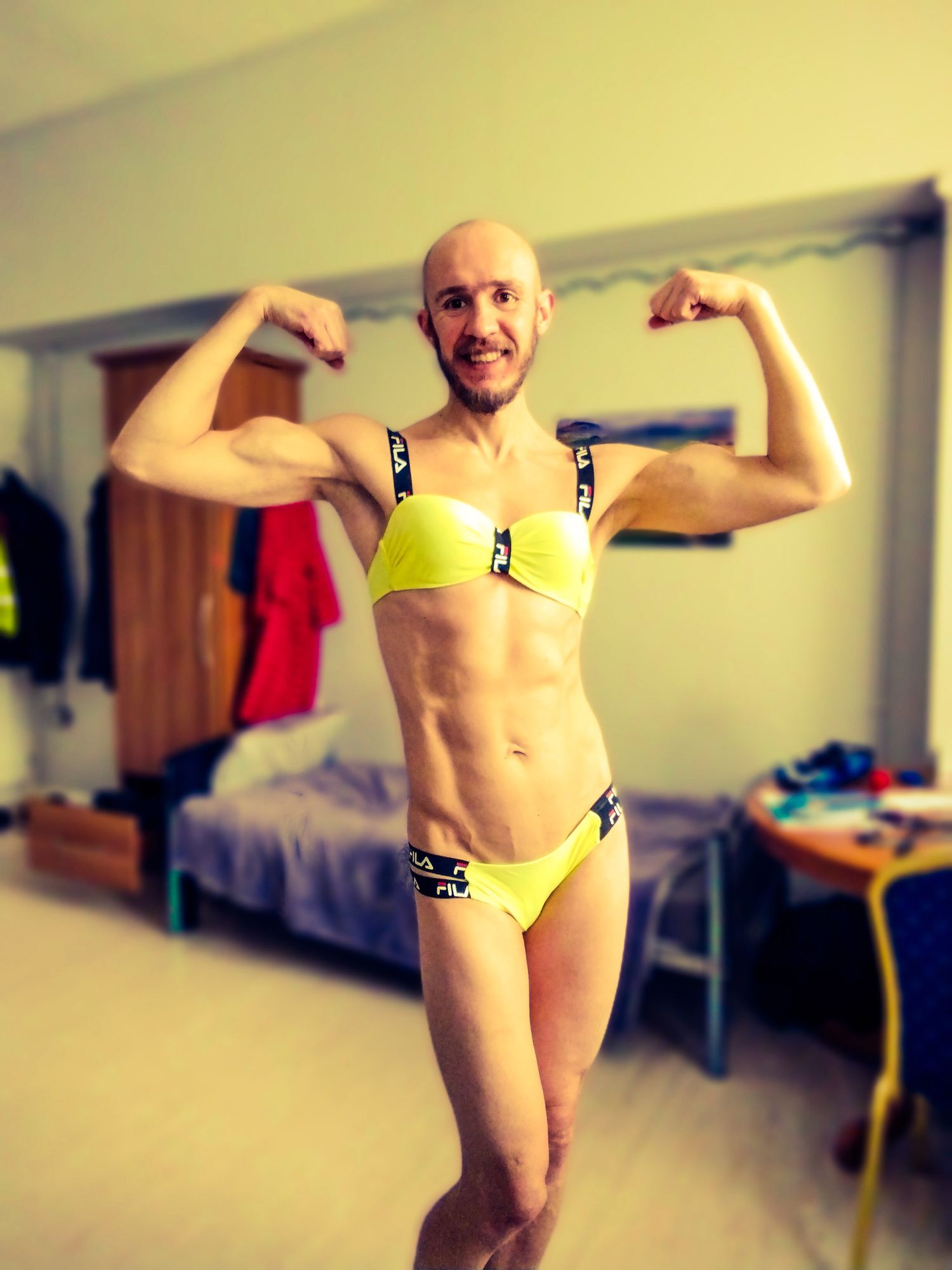 Bearded athletic man posing in yellow swimsuit 