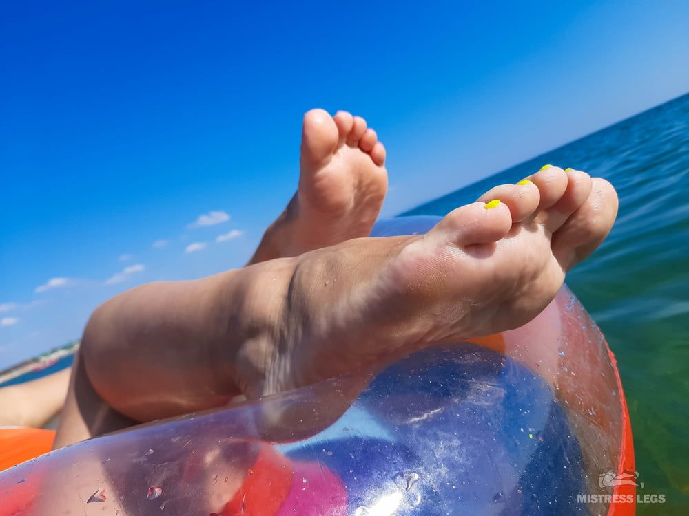 Barefoot wet and wrinkled feet of Mistress on the sea beach #5