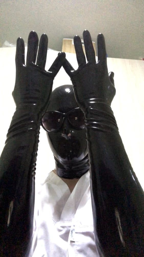 Latex mask and black fetish gloves with medical scrubs 